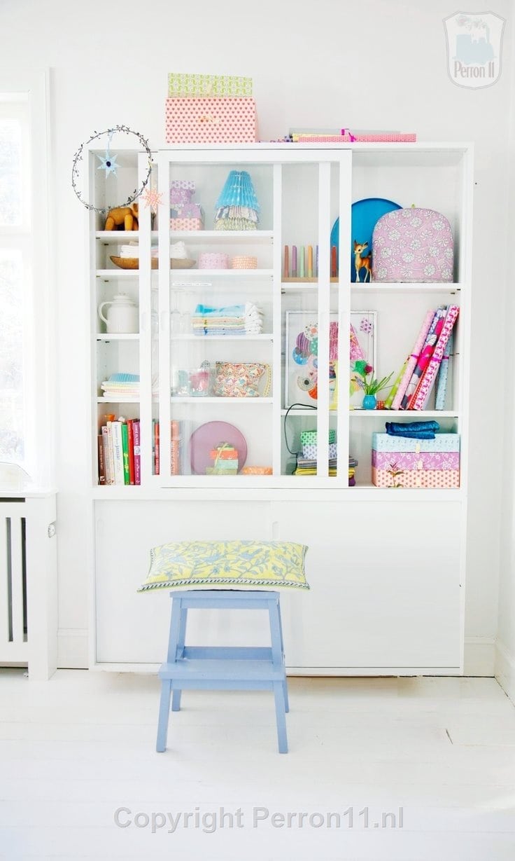 Behang, kinderbehang: witte kast met speelgoed en boeken, kinderkamer decor.