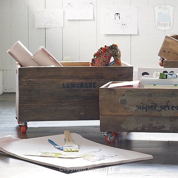 Behang en kinderbehang in een kinderkamer, houten opbergkisten en tekeningen.
