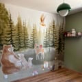 Kinderbehang mural van een geschilderd bos met naaldbomen, paddestoelen en bosdieren zoals drie beren, een hert, eekhoorn, vosjes en een uil