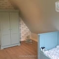 Behang en kinderbehang in kinderkamer met lichtblauwe meubels.