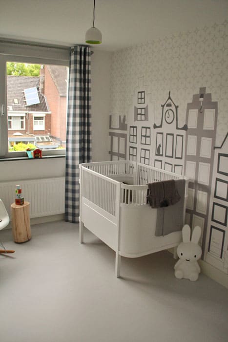 behang-grachtenpandjes-amsterdam-babykamer Behang en kinderbehang in een kinderkamer met stadselementen.
