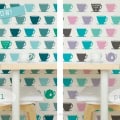 Behang met theekopjes, kinderbehang, blauw, pastel en zwart tinten.