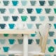 Behang met theekopjes in teal, blauw en groen, kinderbehang.