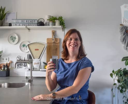 Vrouw met smartphone in keuken, behang, kinderbehang.