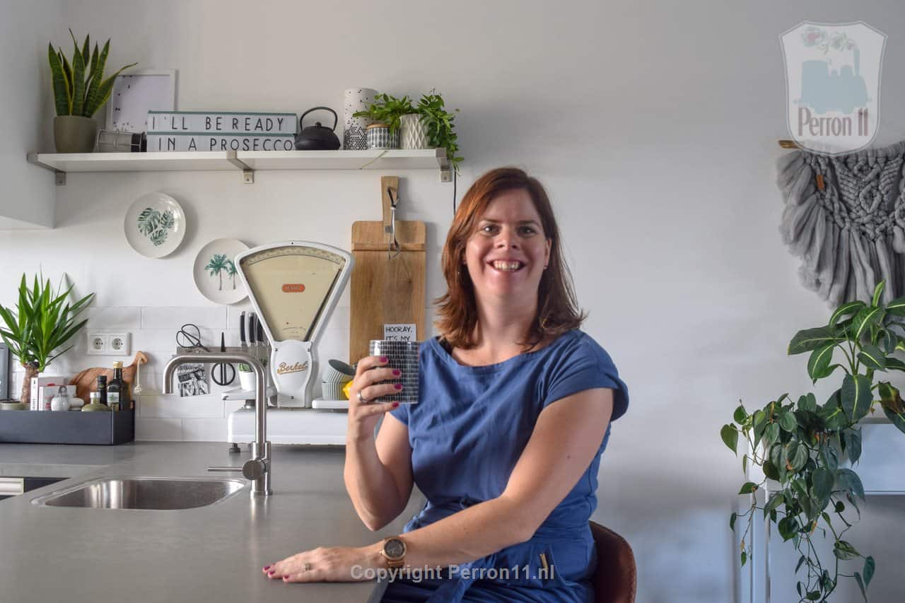 Vrouw met smartphone in keuken, behang, kinderbehang.