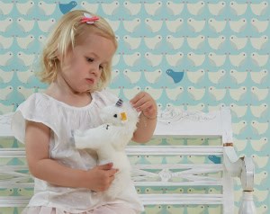 kinderbehang-vogels-retro-patroon-blauw kinderbehang met vogelpatroon in lichtblauw met meisje ervoor