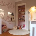 Kinderbehang met boom en huisjes in kinderkamer.