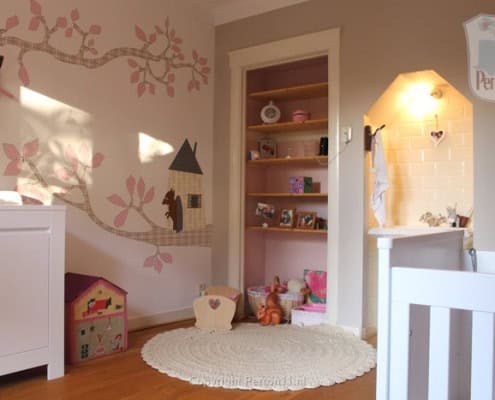 Kinderbehang met boom en huisjes in kinderkamer.