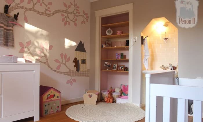 Kinderbehang met boom en huisjes in kinderkamer.