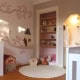 Kinderbehang met boom en huisjes in kinderkamer.