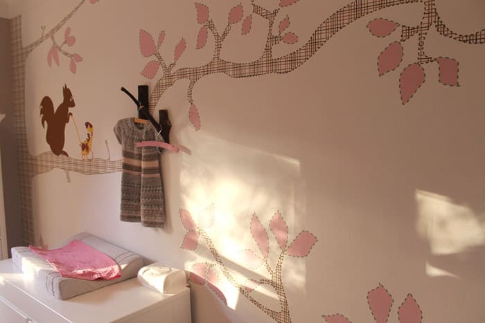 kinderkamer-eekhoorn-origineel-behang-hip2 Behang met kinderbehang met takken en bladeren in roze tinten.