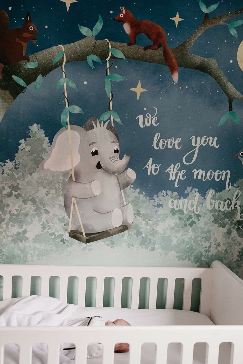 Behang, kinderbehang met een olifant op een schommel onder een boom.