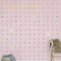 Behang, kinderbehang met roze stippen en pastelkleuren.
